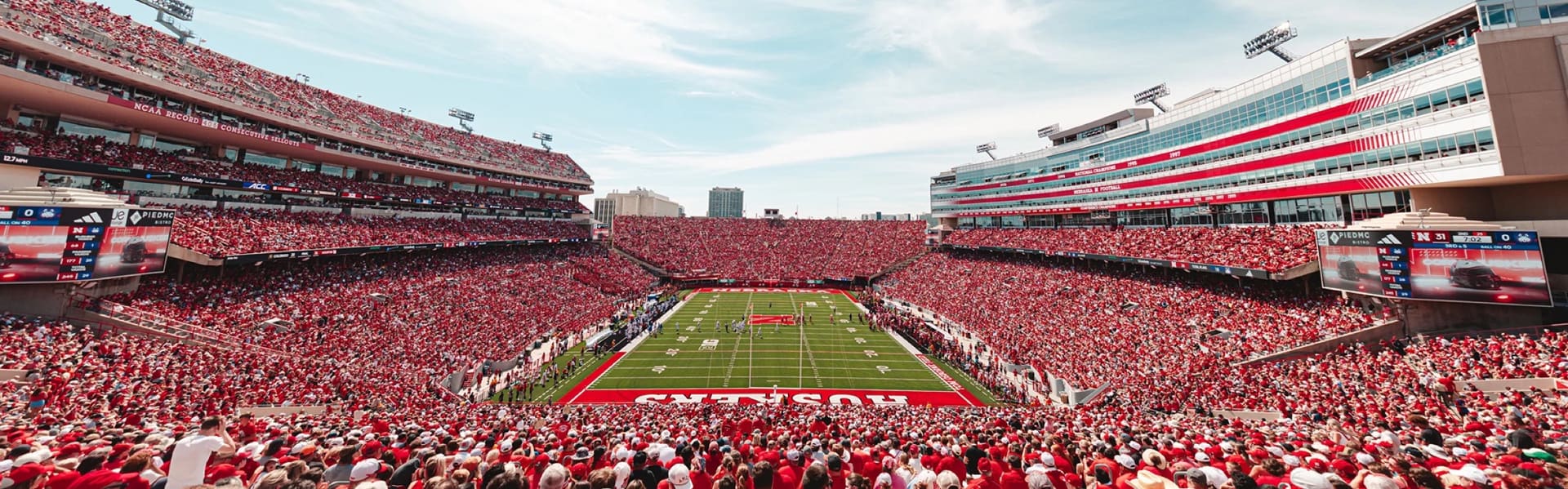 Memorial Stadium full to capacity on a Saturday, the stands solid red from field to roofline