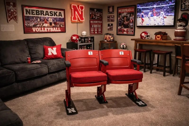 An original pair of red Memorial Stadium seats installed in a Husker fan's basement